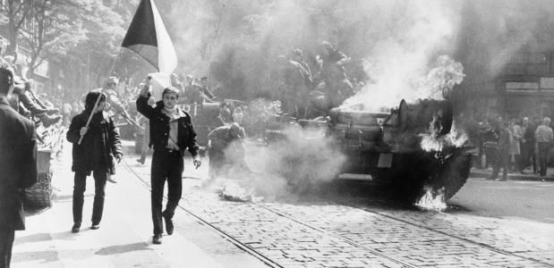 Tsjecho-Slowaken met hun vlag naast een brandende tank in Praag in 1968