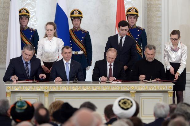 De Russische president Poetin ondertekent in 2014 de toetreding tot de Krim tot de Russische Federatie.