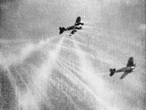Camerabeeld vanuit een Spitfire waarbij een Duitse Heinkel onder vuur wordt genomen