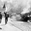Tsjecho-Slowaken met hun vlag naast een brandende tank in Praag in 1968